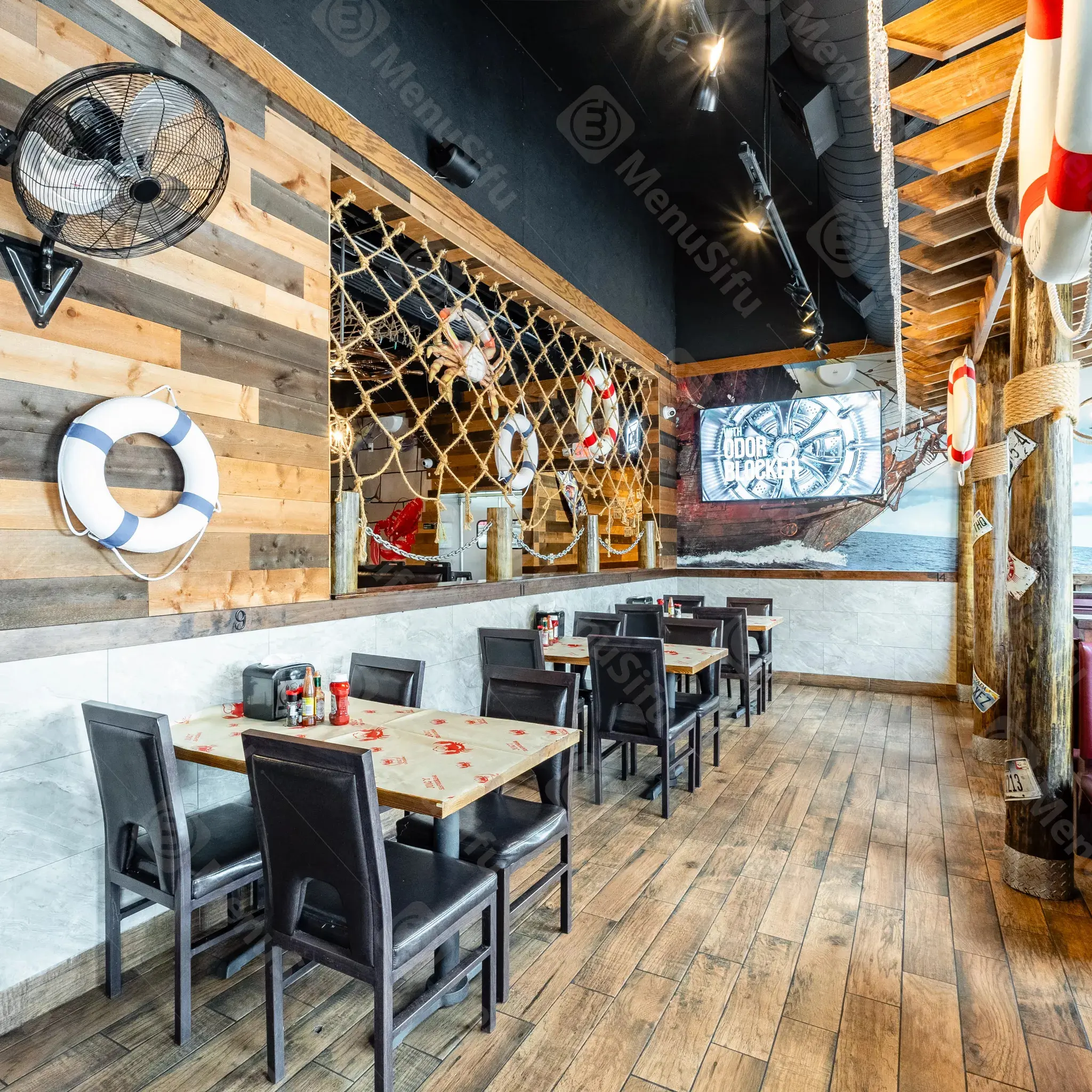 Nautical-themed restaurant interior with life rings and nets at Juicy Seafood And Bar, a Seafood Restaurant in TX