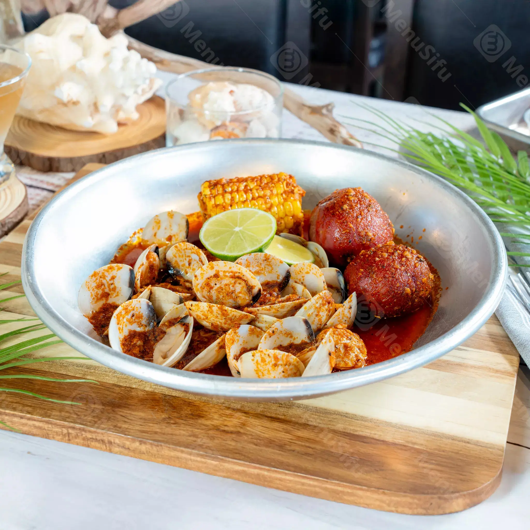 Spicy clams platter with corn and potatoes at Juicy Seafood And Bar, a Seafood Restaurant in TX