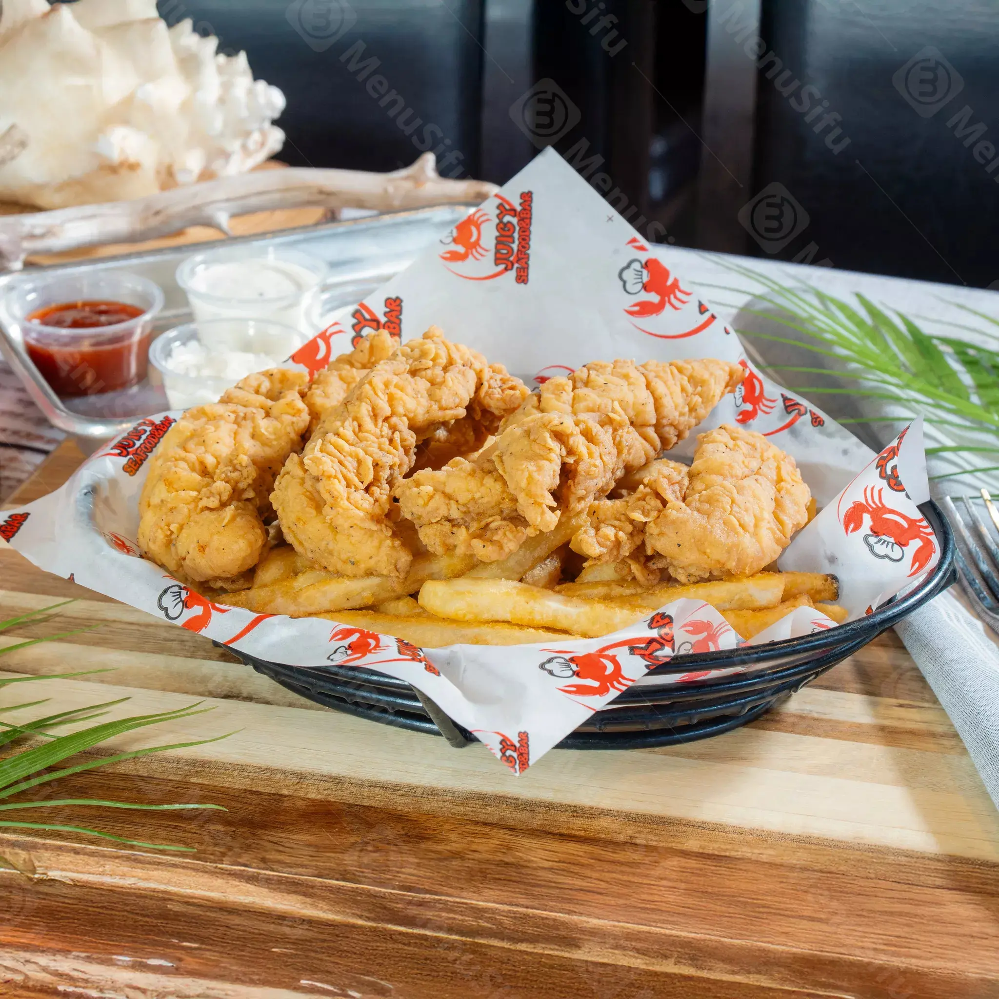 Fried chicken tenders with fries and dipping sauces at Juicy Seafood And Bar, a Seafood Restaurant in TX