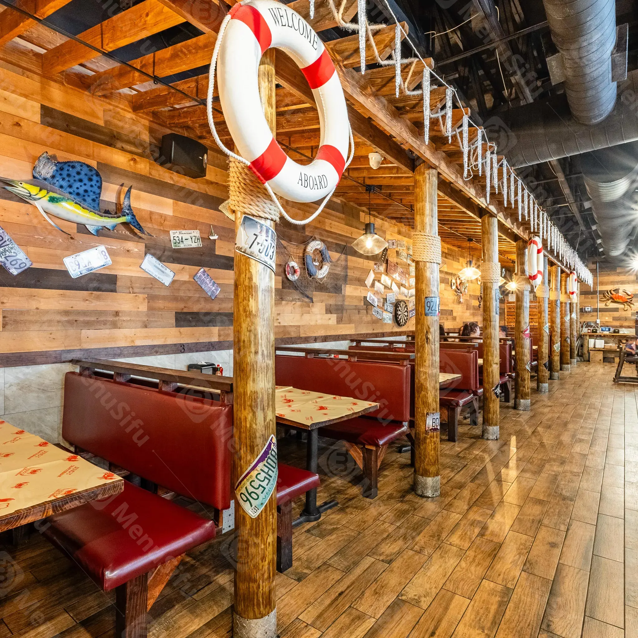 Nautical-themed restaurant interior with fish decor and life rings at Juicy Seafood And Bar, a Seafood Restaurant in TX